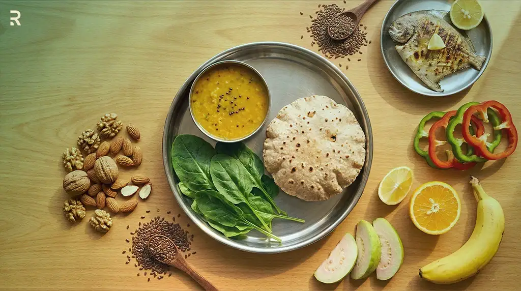 Indian thali with dal, roti and fresh spinach, a grilled pomfret, walnuts, almonds, flaxseed, bell peppers, orange, guava and banana